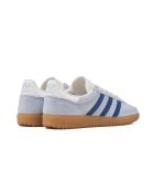 Hand 2 doorzichtige donkerblauwe suède sneakers met hemelsblauwe hemel