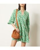 Cara-Kleid gedruckt auf grünem Hintergrund