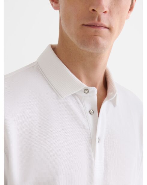 Witte polo met knopen in reliëf